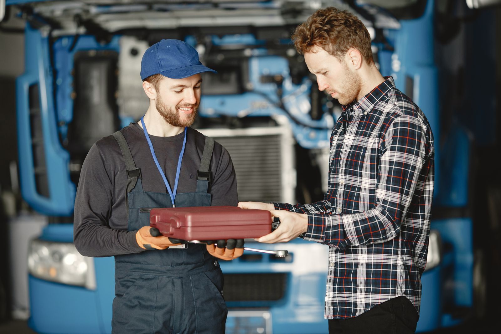 Two workers talking over a toolbox